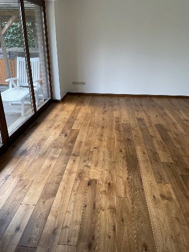 Ein Wohnzimmer mit Holzboden und Glasschiebetüren.