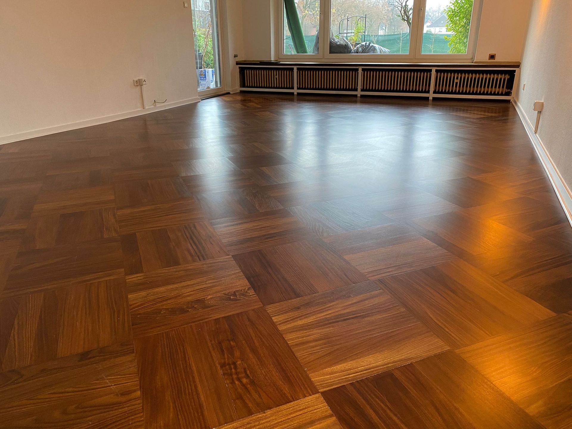 Ein Wohnzimmer mit Holzboden und Fenster.