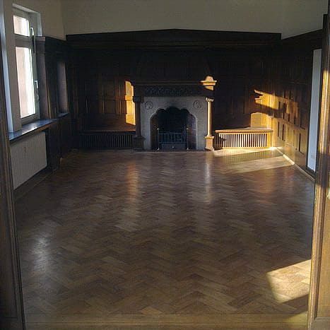 Ein leerer Raum mit Kamin und Holzboden