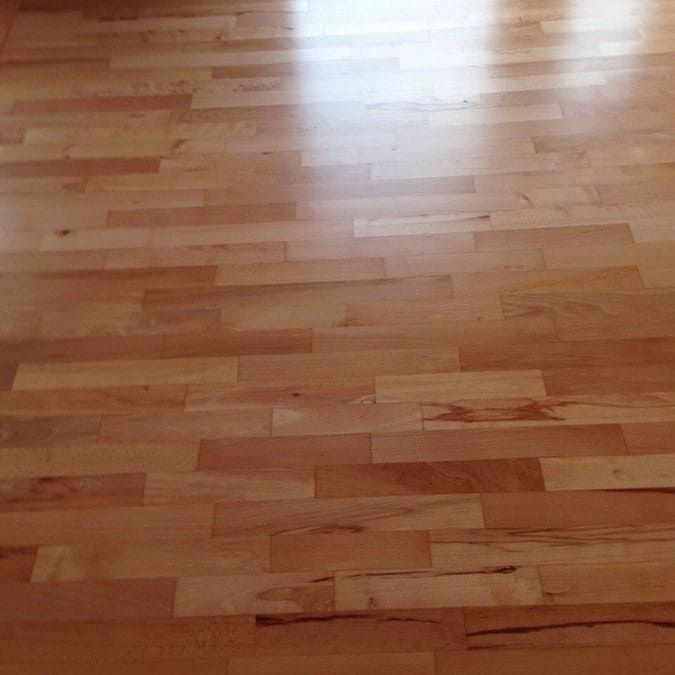 Eine Nahaufnahme eines Holzbodens in einem Raum.