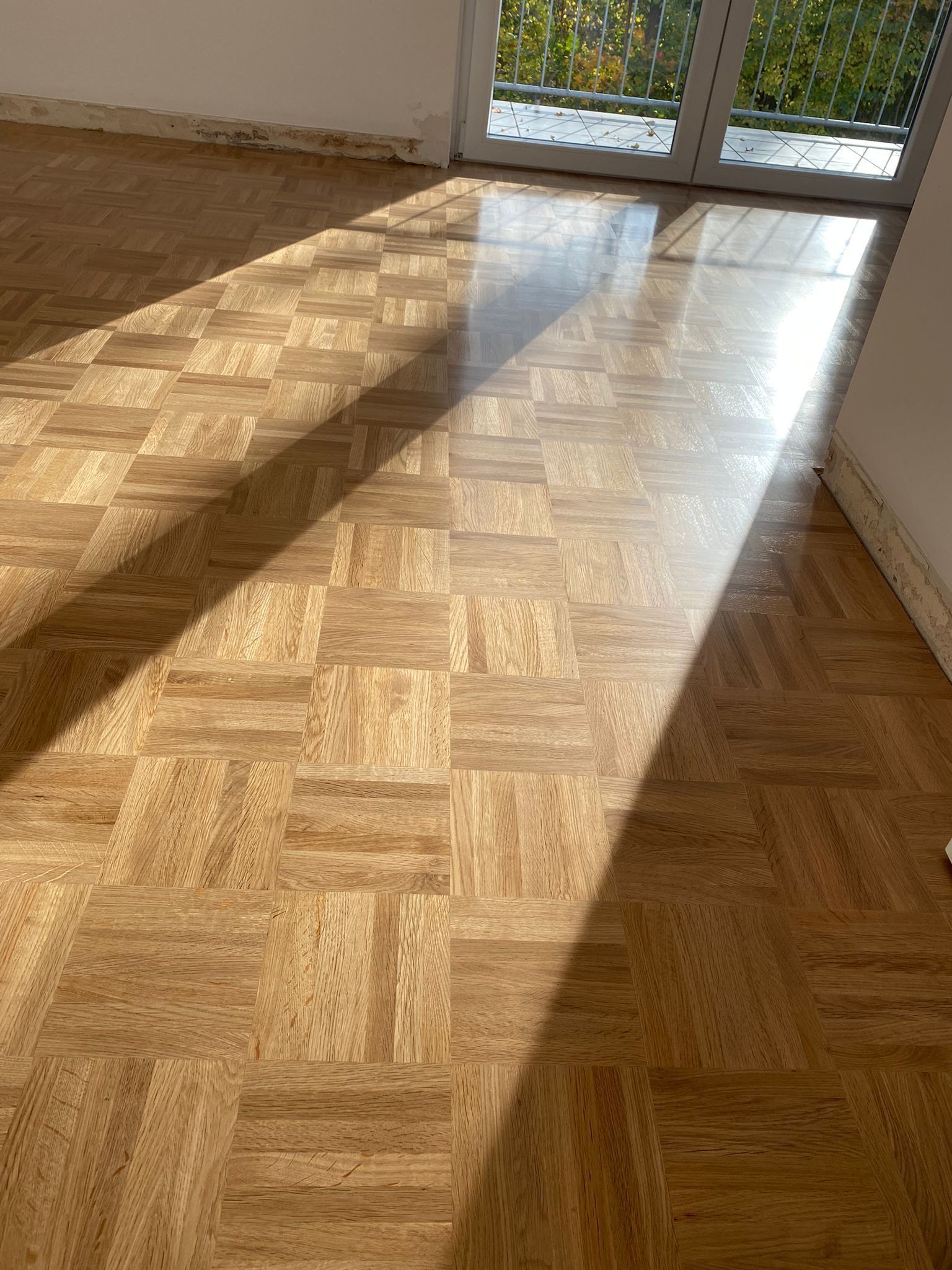 Die Sonne scheint auf einen Holzboden in einem Raum.