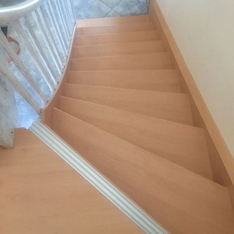 Eine Nahaufnahme einer Holztreppe mit weißem Geländer.