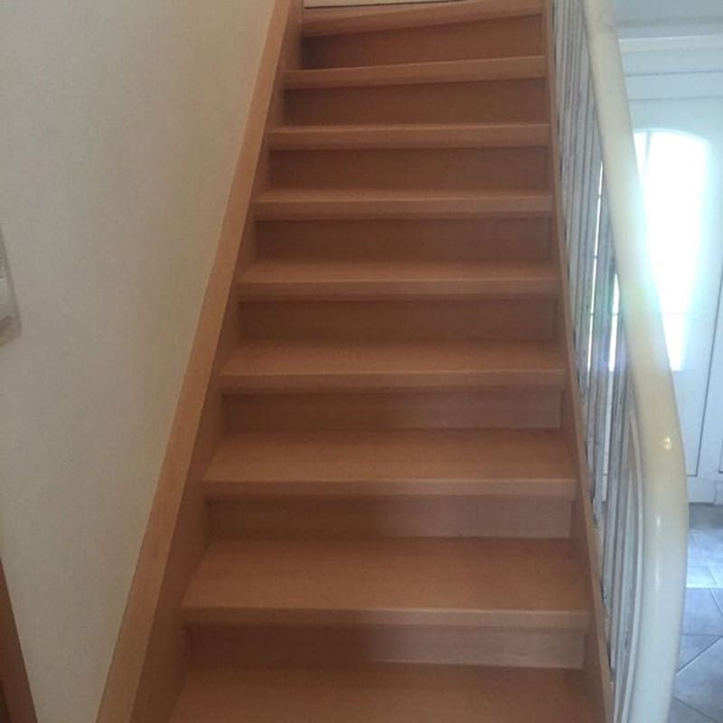 Eine Holztreppe, die in den zweiten Stock eines Hauses führt.