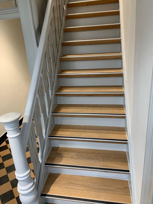 Eine Treppe mit Holzstufen und einem weißen Geländer.