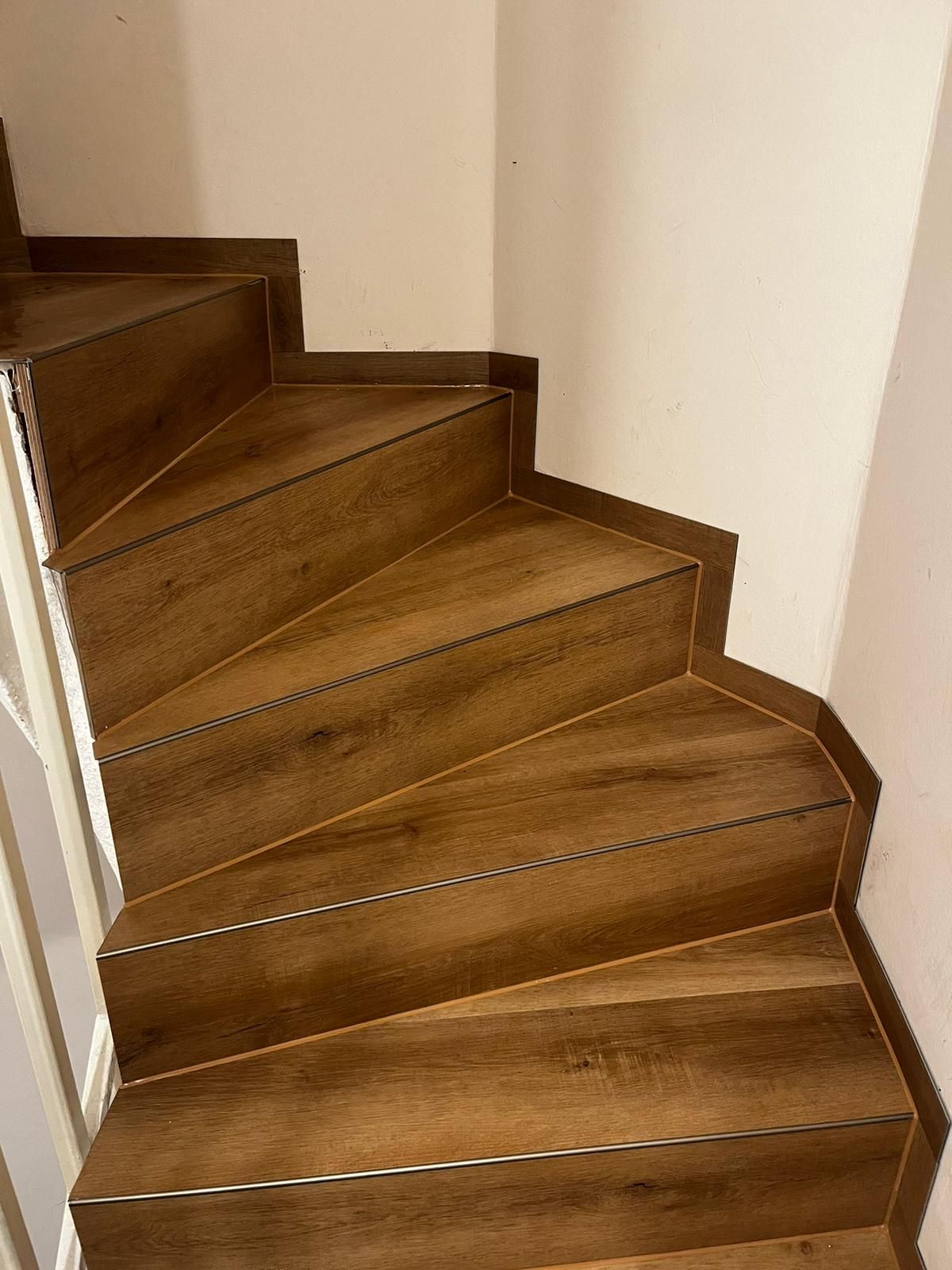 Eine Nahaufnahme einer Holztreppe in einem Haus.