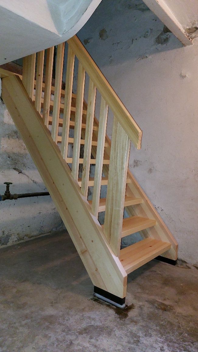 Eine Holztreppe in einem Keller mit einem Holzgeländer