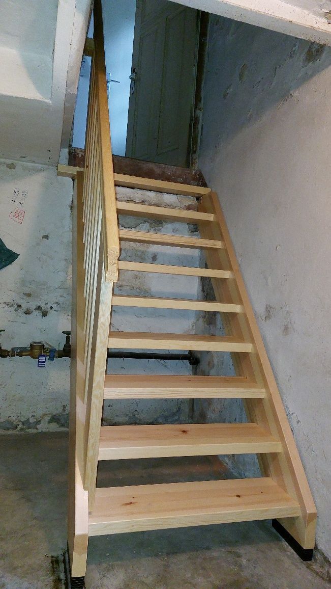 In einem Kellergeschoss wird eine Holztreppe gebaut.