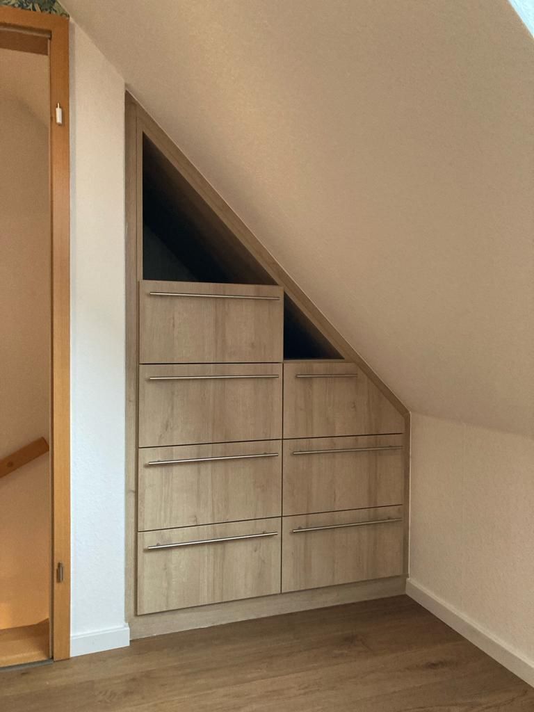 Eine Zimmerecke mit einer Treppe und einer eingebauten Kommode.