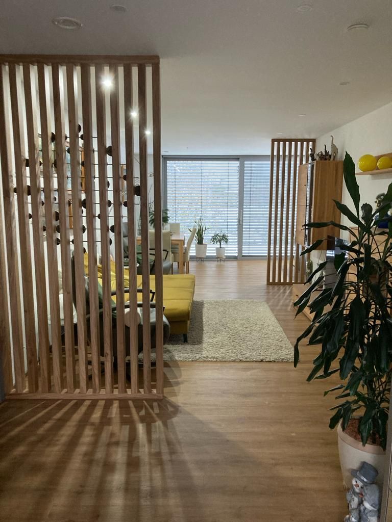 Ein Wohnzimmer mit einer Holztrennwand zwischen Wohn- und Esszimmer.