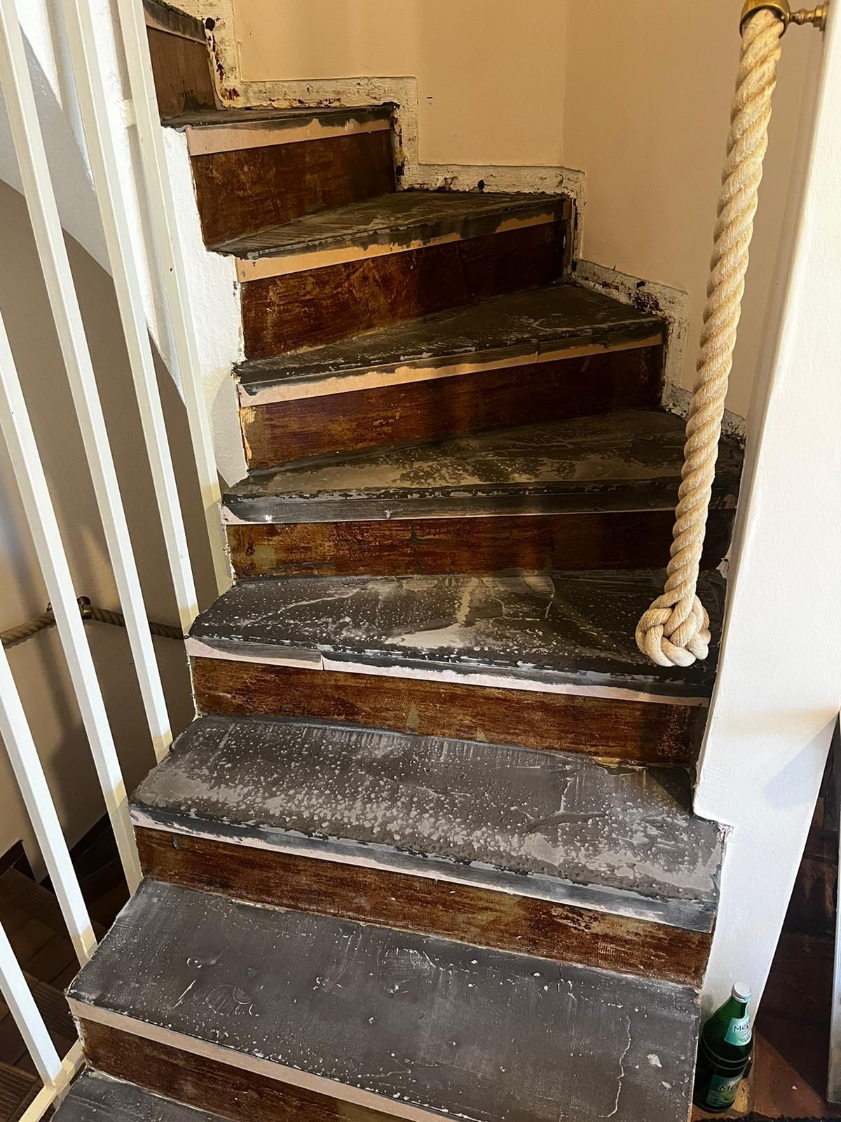 Eine Wendeltreppe mit weißem Geländer und Seilgeländer.