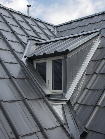 Toit en tuiles grises avec une lucarne.