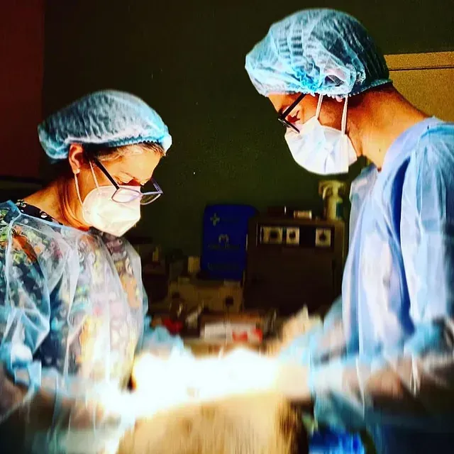 Un hombre y una mujer están operando a un paciente