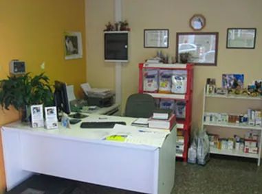 Un escritorio blanco con una computadora encima en una habitación.