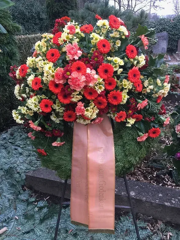 Tannenkranz und Blumengesteck mit Schärpe