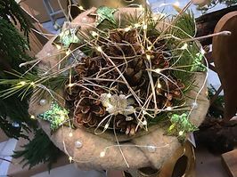 Weihnachtliche Dekoration mit Tannzweigen, Tannzapfen und Lichterketten