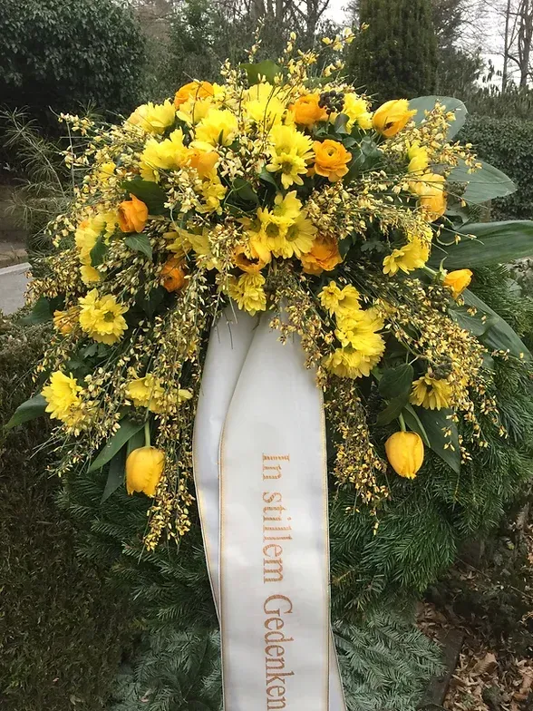 Trauerfloristik mit Tannenzweigen und einer Schärpe