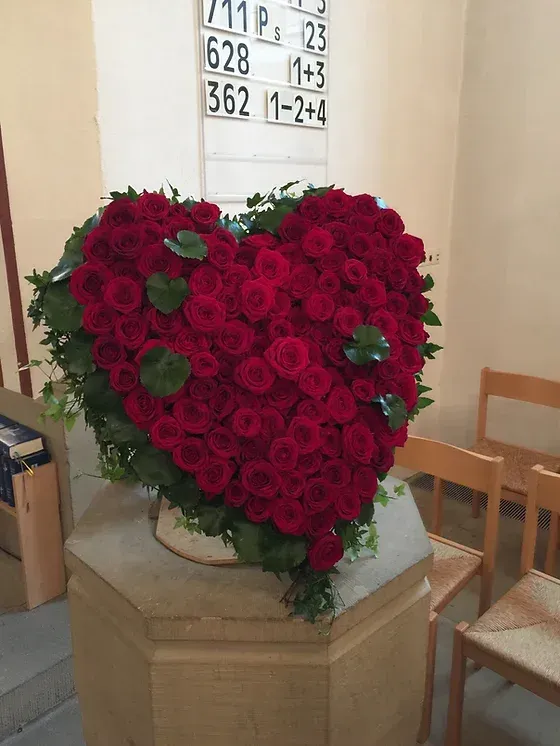 Blumenarragement als Herz aus roten Rosen
