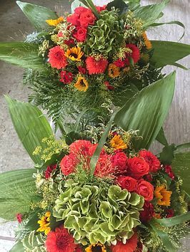 Große Blumengestecke mit Farnen und Palmblättern für einen festlichen Anlass 