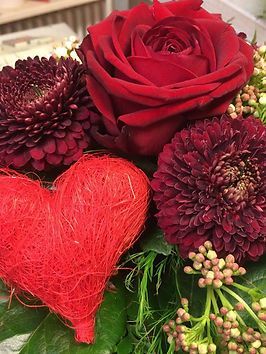 Blumengesteck in dunklem Rot mit einem Herz