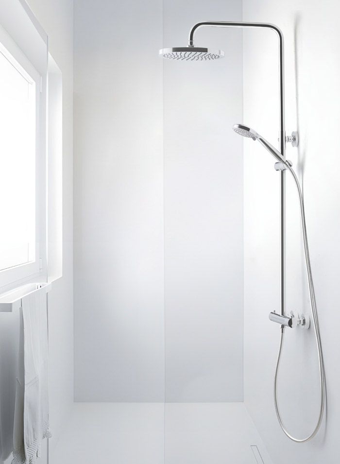 Accesorio de ducha contra una pared blanca con un cabezal de ducha grande y una ducha de mano.