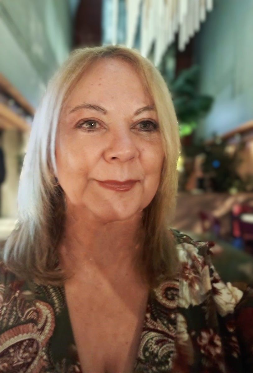 Una mujer con una camisa de cachemira sonríe a la cámara.