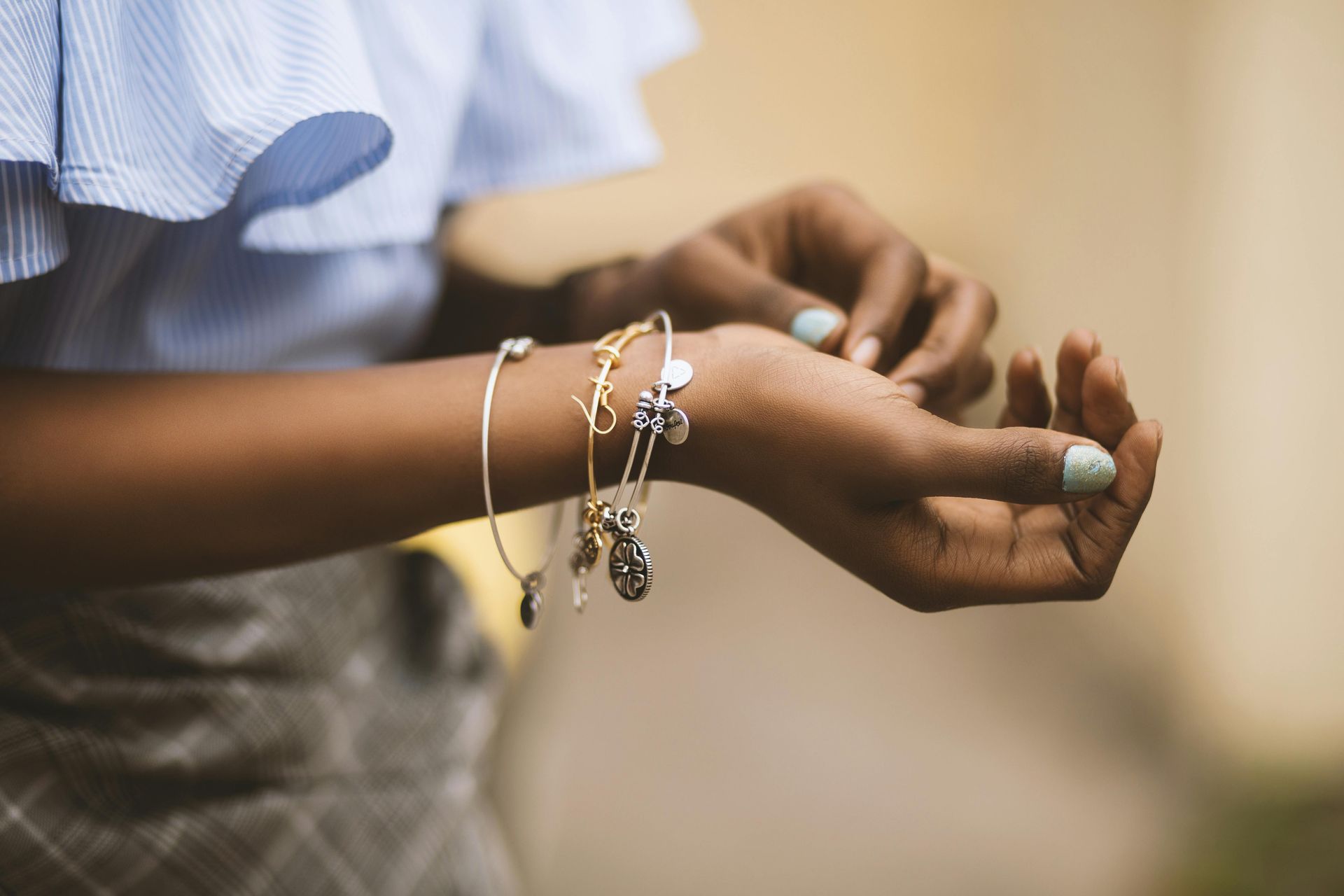 Una mujer lleva muchas pulseras en su muñeca.