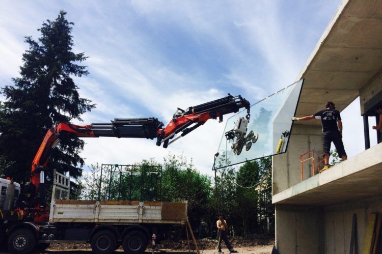 Pose de vitre avec grue, installation du vitrage en cours