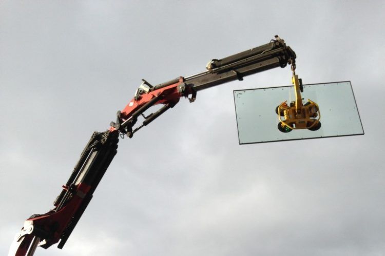 Gros plan sur une grue tractant un carreau de verre