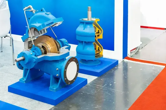 Bombas de agua industriales azules, una abierta que muestra el funcionamiento interno, en exhibición.