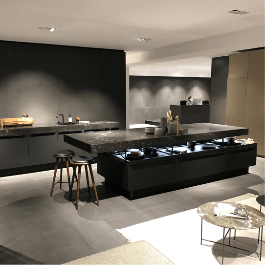 Eine Küche mit schwarzen Schränken und einer großen Insel