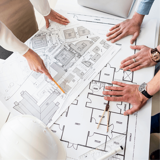 Eine Gruppe von Leuten betrachtet den Grundriss eines Hauses.