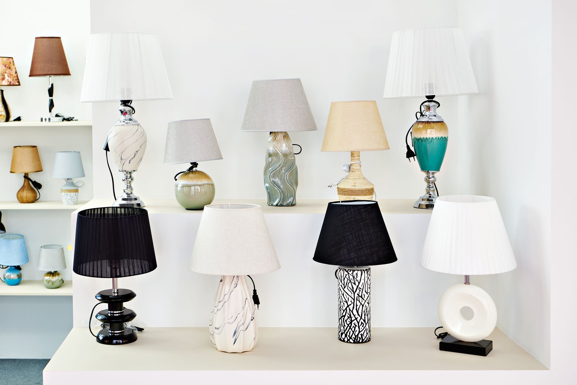 Des lampes alignées sur des étagères blanches