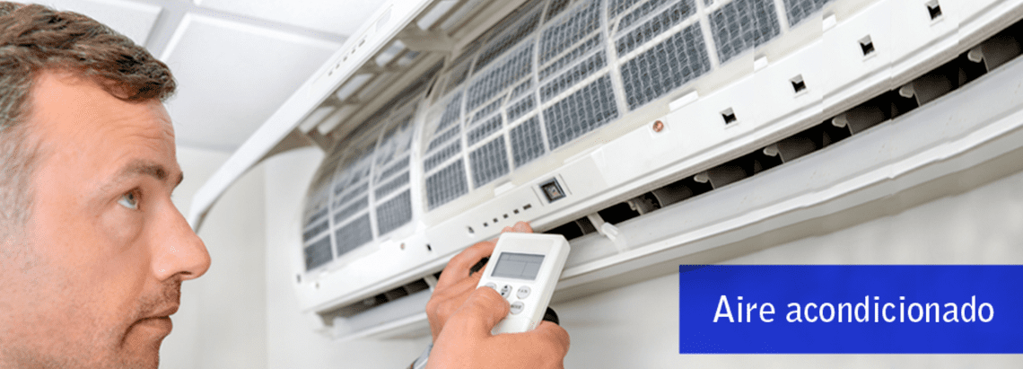 Hombre sosteniendo un control remoto ajustando un aire acondicionado etiquetado como 