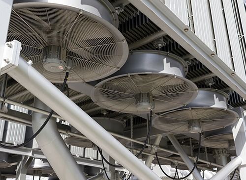 Ventiladores industriales de refrigeración montados sobre una estructura metálica, vista de cerca.