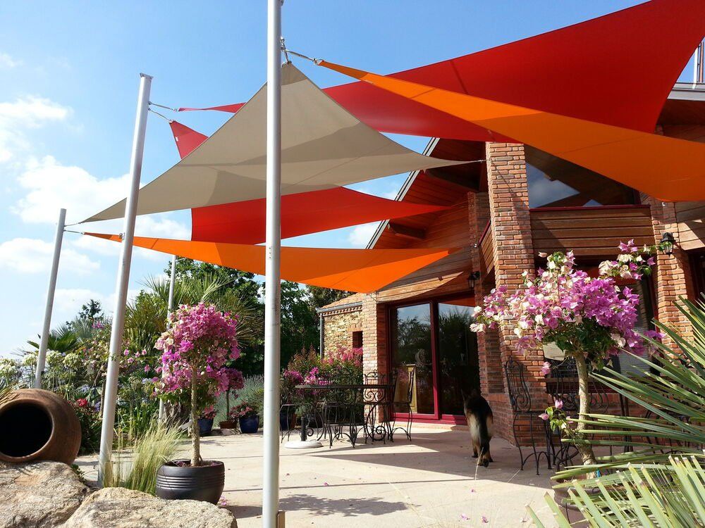 Nombreux voiles d'ombrage colorés protégeant une terrasse