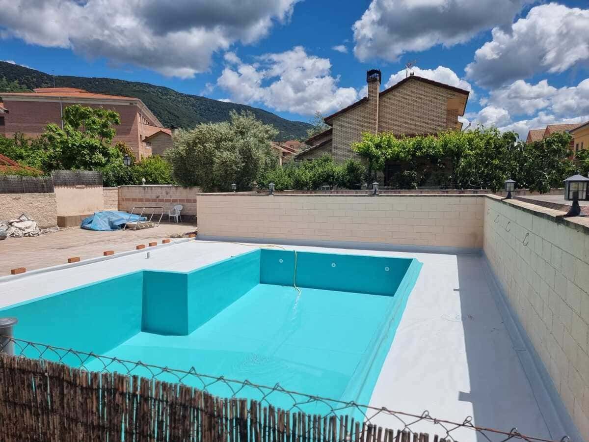Una gran piscina está rodeada por una valla de alambre de púas.