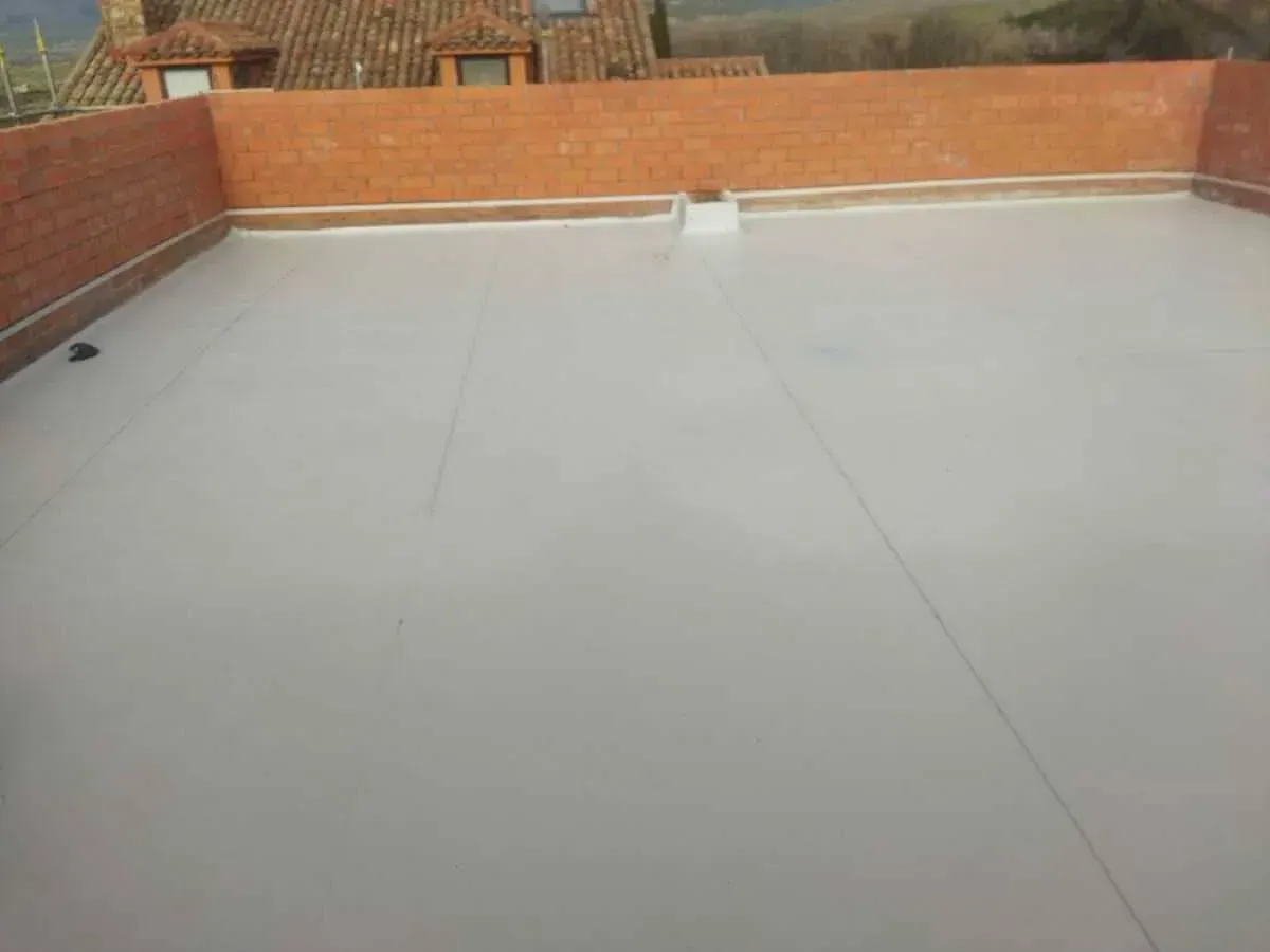 Un techo blanco con una pared de ladrillos al fondo.