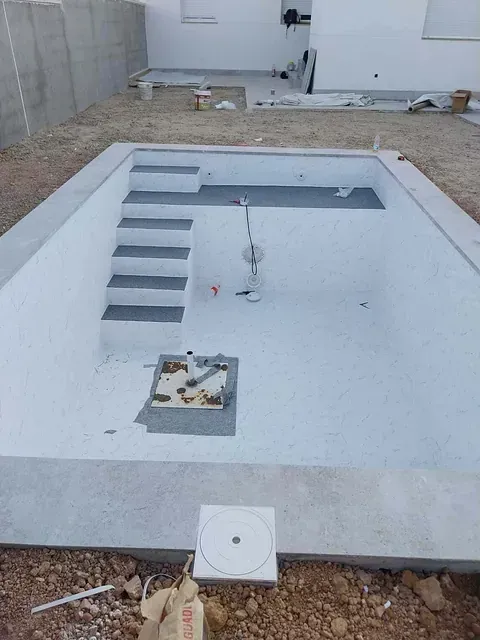 Se está construyendo una piscina en el patio trasero de una casa.