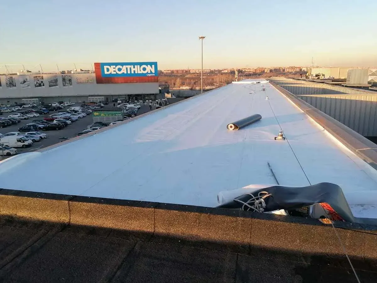 El tejado de un edificio con un cartel de Decathlon al fondo.