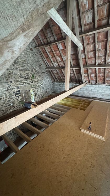 Couloir vide avec parquet clair et murs blancs, vu d'un angle bas.