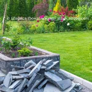 In einem Garten liegt ein Steinhaufen auf dem Boden. Karl Müller Garten- und Landschaftsbau