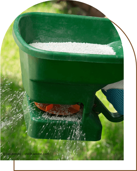 Ein Mann besprüht einen Rasen mit einer Sprühpistole. Karl Müller Garten- und Landschaftsbau