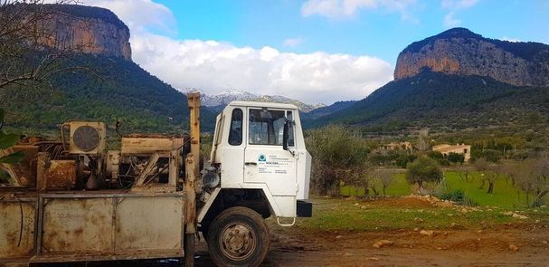 Un camión blanco está estacionado frente a una montaña.