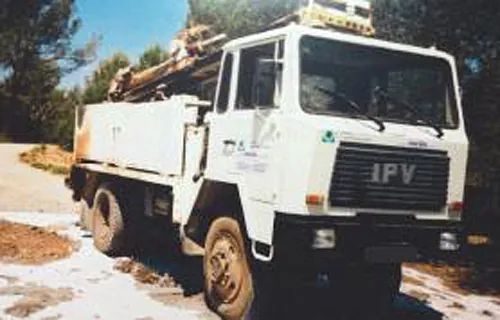 Un camión blanco está estacionado al costado de un camino de tierra.