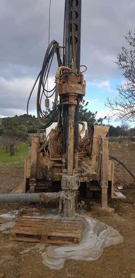 Una gran máquina está parada en el medio de un campo de tierra.