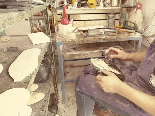 Monsieur Milioni qui fabrique une chaussure