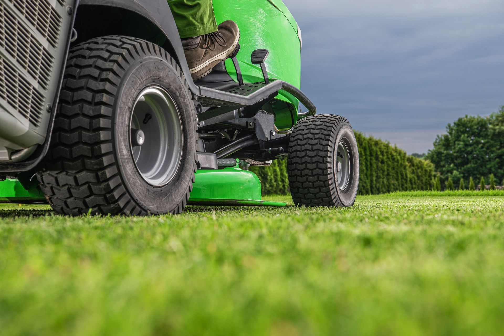 Un homme sur un tracteur tondeuse vert