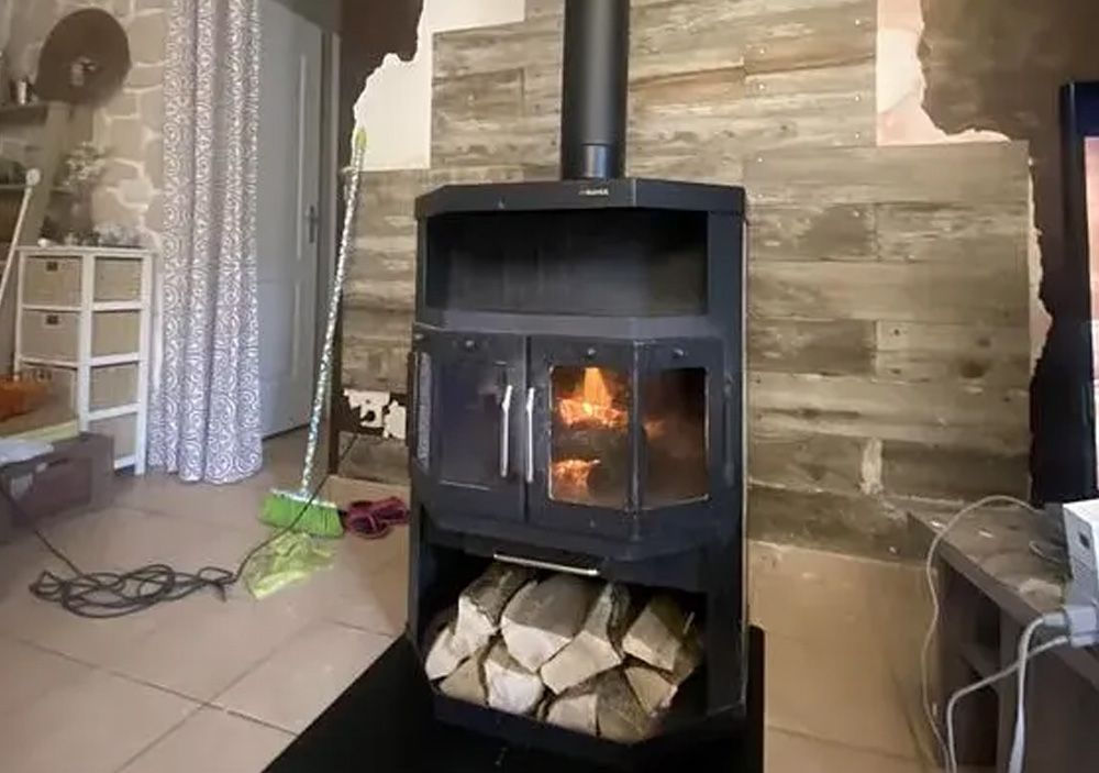 Poêle à bois noir en fonctionnement contre un mur