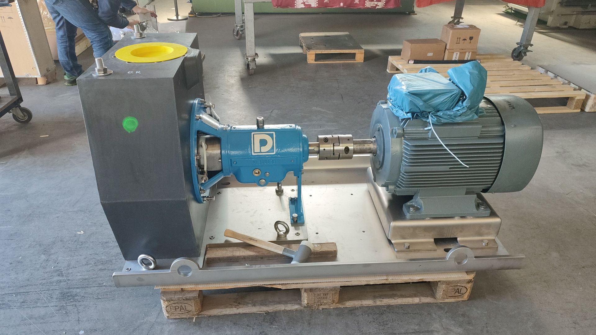 Industriepumpenbaugruppe mit blauer Pumpe und grauem Motor auf einer Palette.