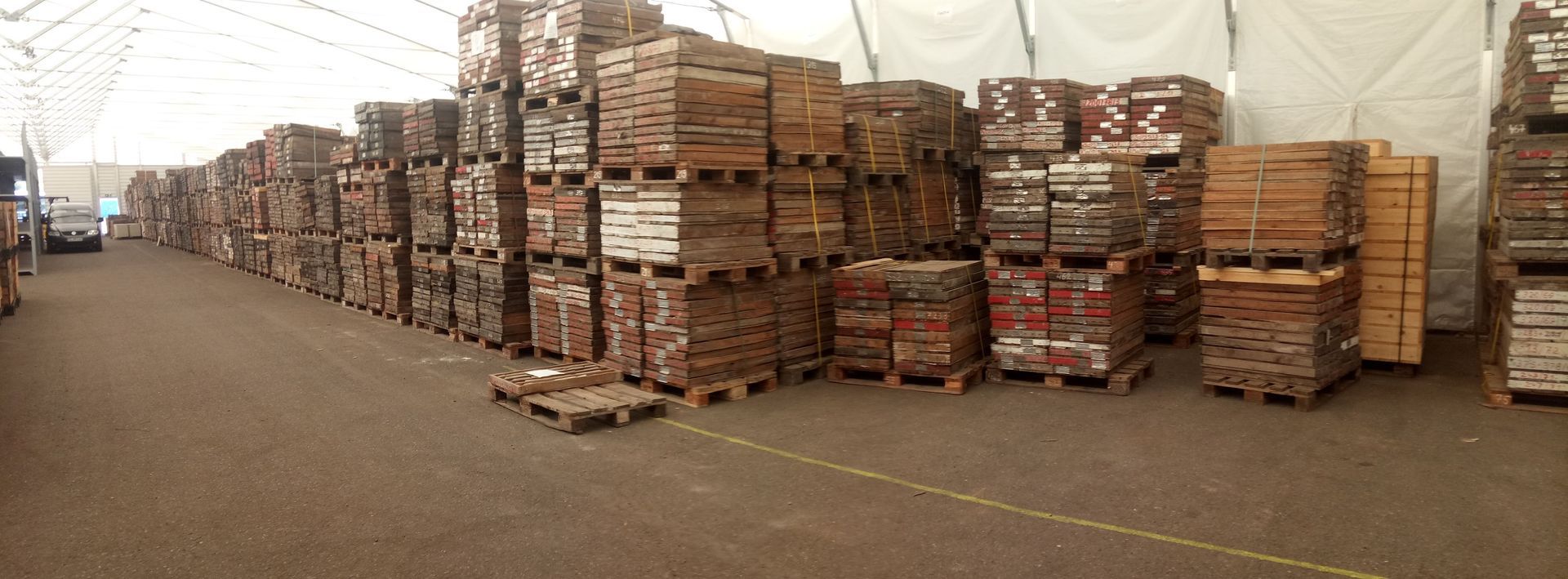 In einem Lagerhaus stapeln sich Ziegelsteine ​​auf Paletten, aufgereiht in Reihen.